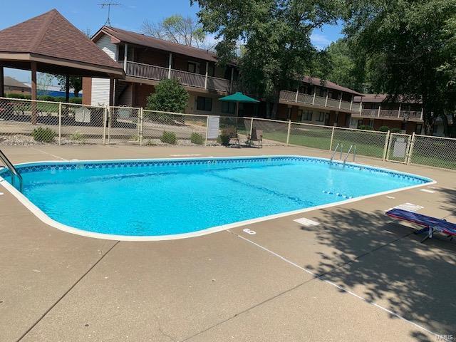 pool featuring fence and a gazebo