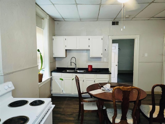 kitchen with white cabinets, a drop ceiling, sink, and white range with electric stovetop