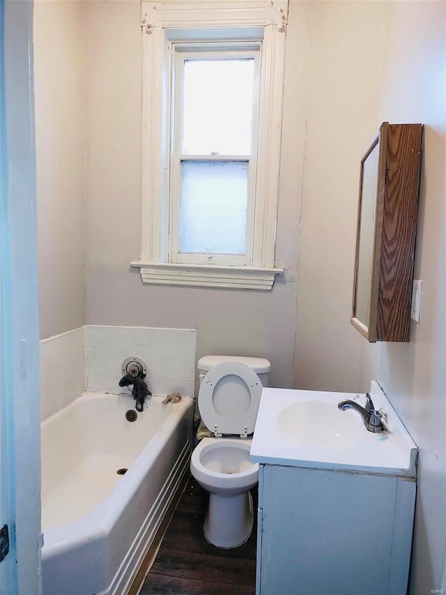 bathroom featuring a bathing tub, wood-type flooring, vanity, and toilet