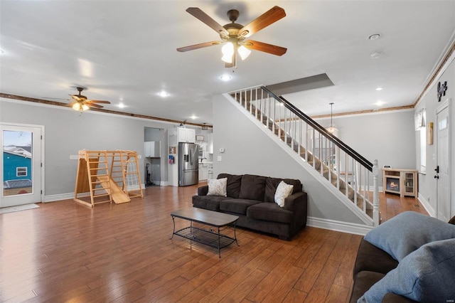 living room featuring a barn door, baseboards, ornamental molding, stairway, and hardwood / wood-style floors