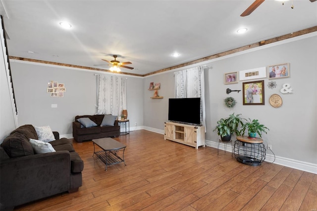 living area featuring light wood-style floors, ceiling fan, and baseboards