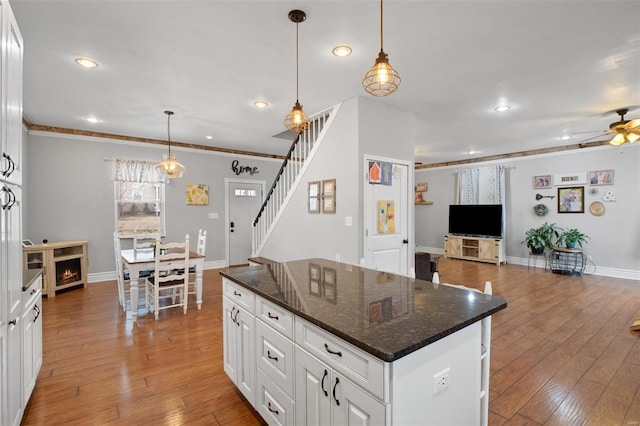 kitchen with light wood finished floors, recessed lighting, open floor plan, white cabinets, and ceiling fan