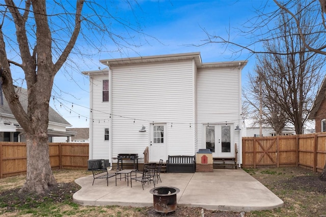 back of house with entry steps, a fenced backyard, and a patio