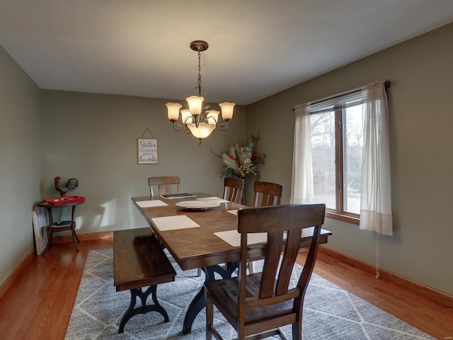 dining area featuring an inviting chandelier and hardwood / wood-style flooring