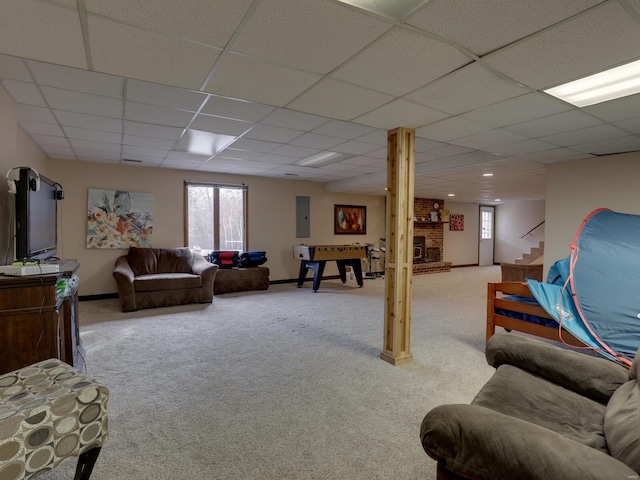 carpeted living room featuring a healthy amount of sunlight and a drop ceiling