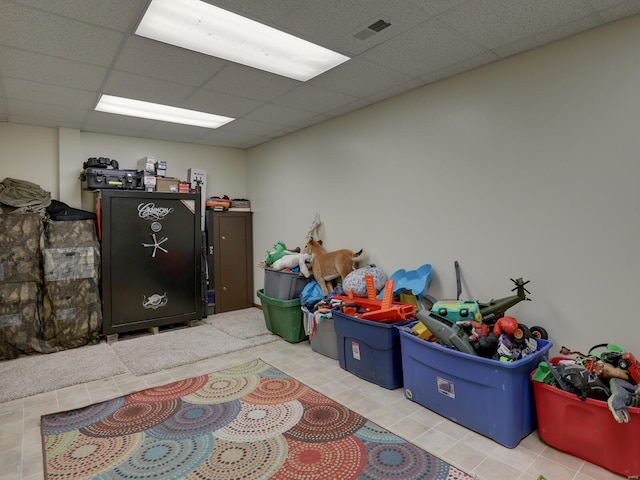 rec room with a paneled ceiling and light tile patterned floors