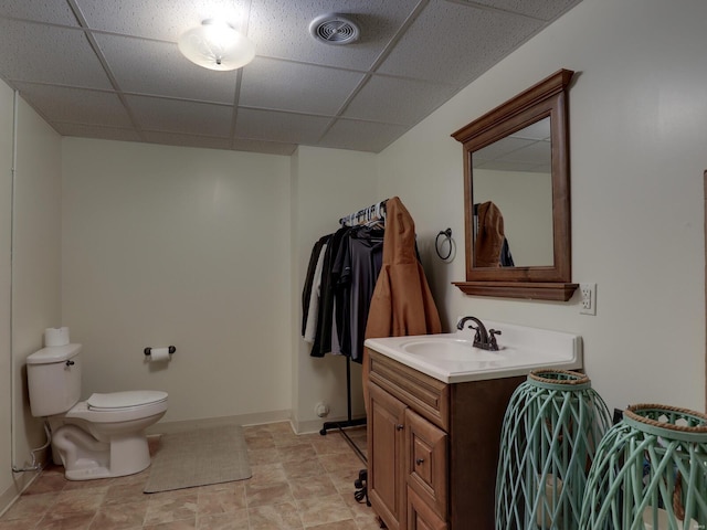 bathroom with vanity, a drop ceiling, and toilet