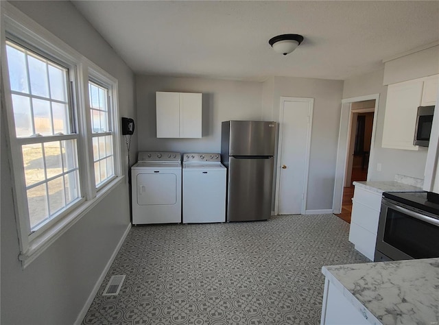 kitchen with appliances with stainless steel finishes, visible vents, independent washer and dryer, and baseboards