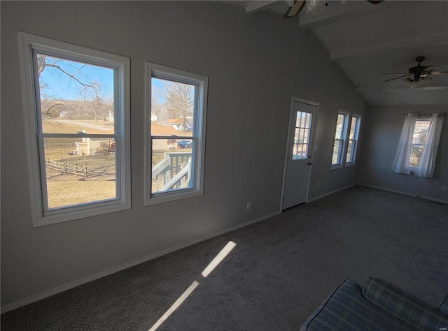 spare room with lofted ceiling with beams, ceiling fan, dark carpet, and baseboards