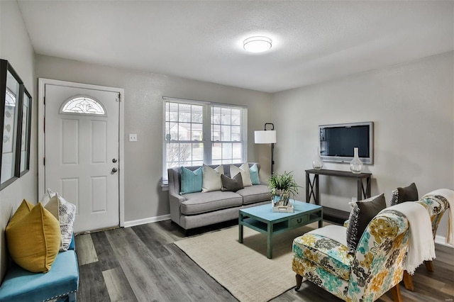 living room with dark wood-type flooring and a textured ceiling