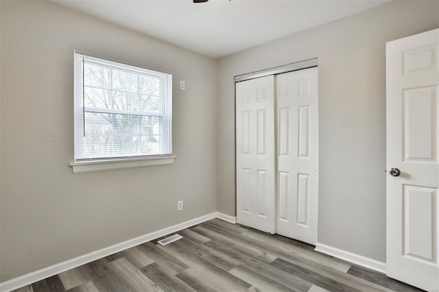 unfurnished bedroom featuring wood-type flooring and a closet