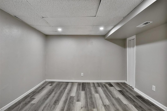 basement featuring hardwood / wood-style floors and a drop ceiling