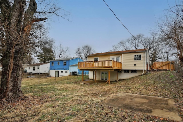 back of house featuring a wooden deck and a yard