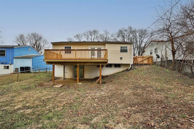 rear view of property with a wooden deck and a lawn