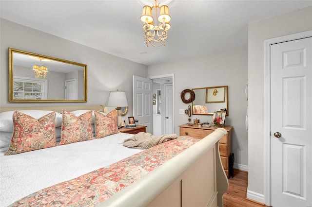 bedroom with a chandelier and light hardwood / wood-style floors