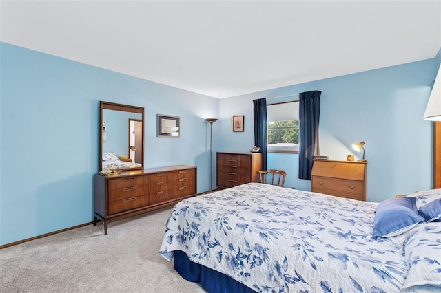 bedroom with light carpet and baseboards