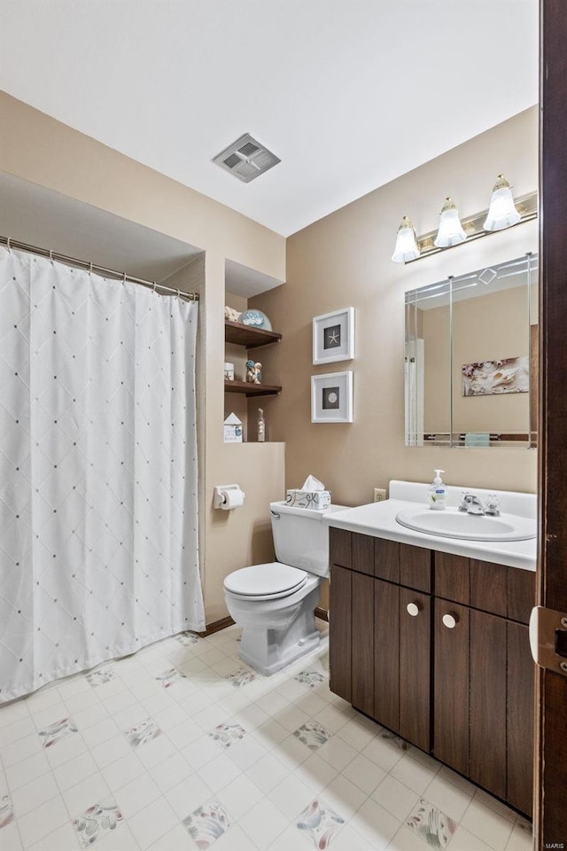 bathroom featuring toilet, vanity, and visible vents