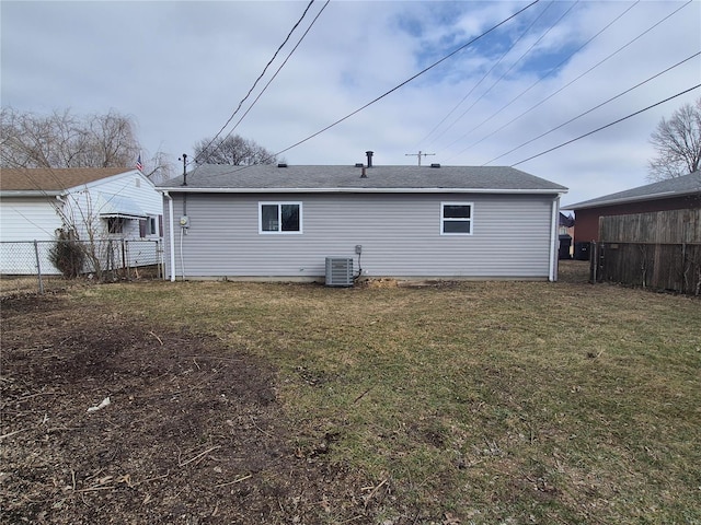 rear view of property with a yard and central air condition unit