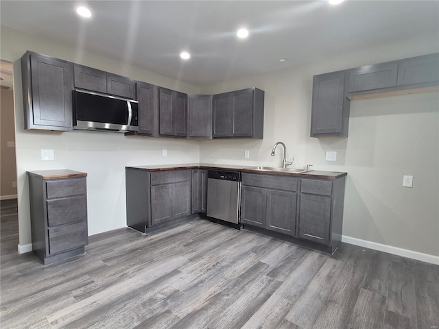 kitchen featuring appliances with stainless steel finishes, sink, and light wood-type flooring