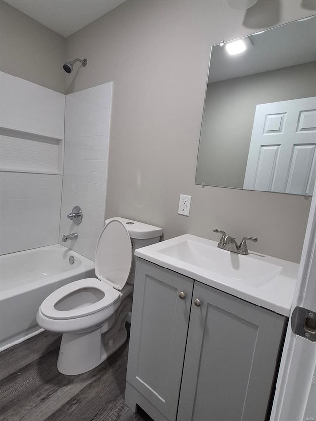 full bathroom featuring wood-type flooring, toilet,  shower combination, and vanity