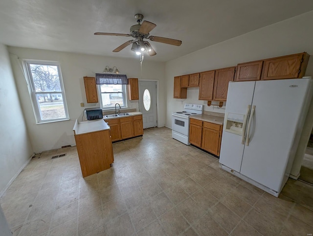 kitchen with ceiling fan, a center island, sink, and white appliances