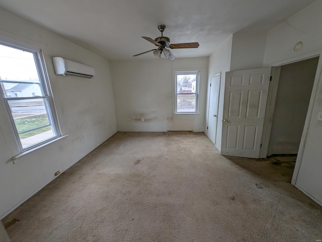 spare room with light carpet, ceiling fan, and a wall mounted AC