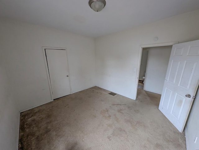 unfurnished room featuring light carpet