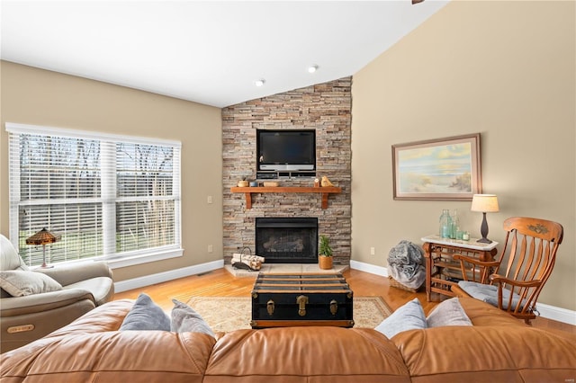 living room with a fireplace, vaulted ceiling, and light wood-type flooring