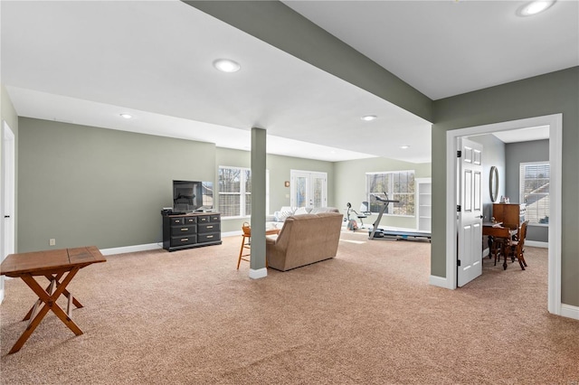 living room with french doors, a healthy amount of sunlight, and carpet