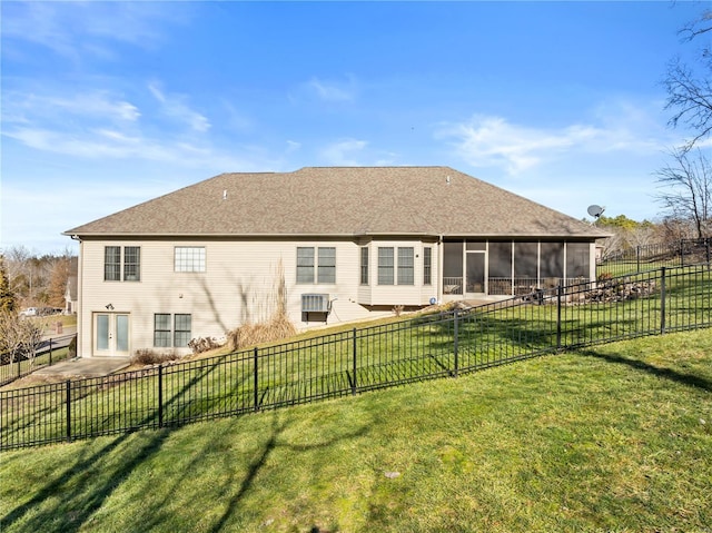 rear view of property featuring a sunroom and a lawn