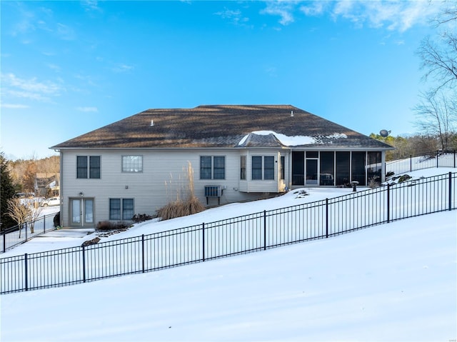 snow covered house with a sunroom