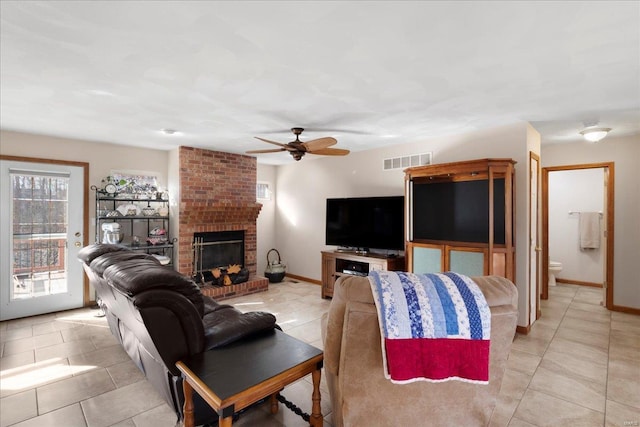 living area with a brick fireplace, light tile patterned floors, baseboards, and visible vents