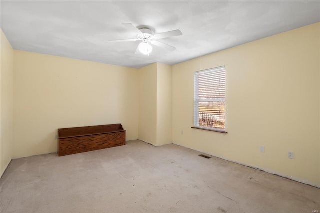 empty room with visible vents, a ceiling fan, and carpet floors