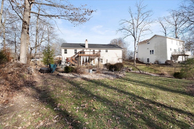 back of property with a yard, stairway, a chimney, and a deck