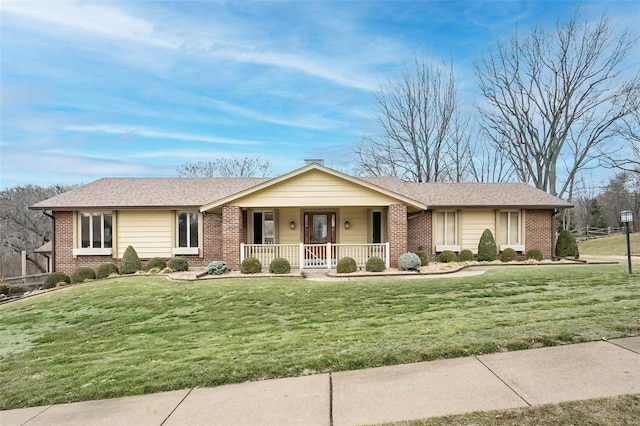 ranch-style house featuring covered porch and a front lawn