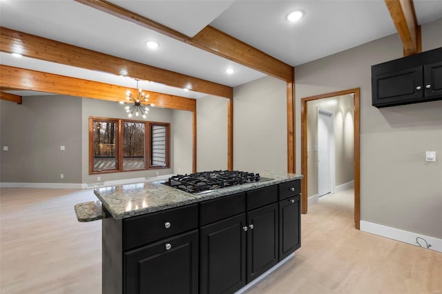 kitchen featuring hanging light fixtures, stainless steel gas cooktop, beamed ceiling, and a kitchen island