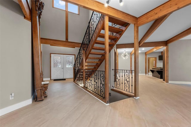 stairway with beamed ceiling, wood-type flooring, and a notable chandelier