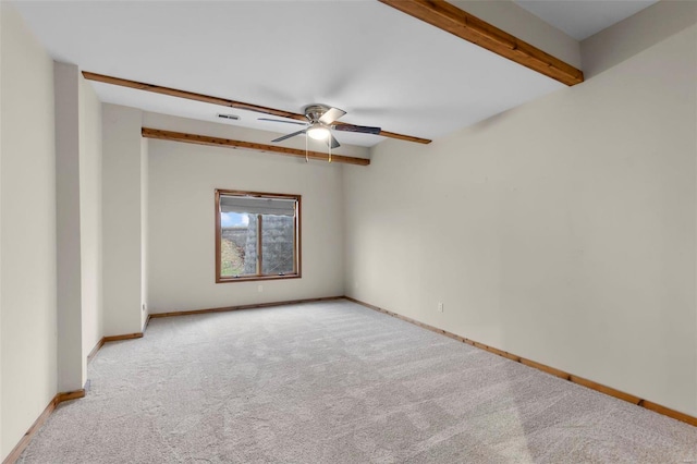 carpeted spare room featuring ceiling fan and beam ceiling