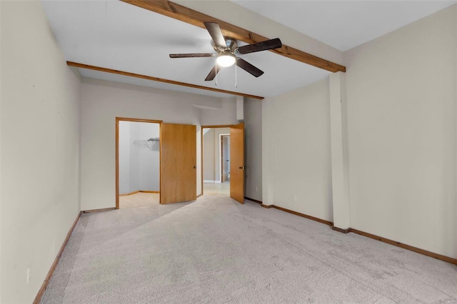 empty room with light carpet, ceiling fan, and beamed ceiling