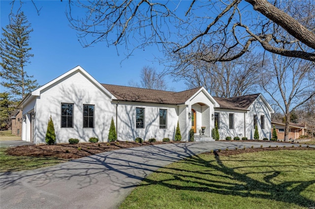 view of front facade featuring aphalt driveway and a front lawn