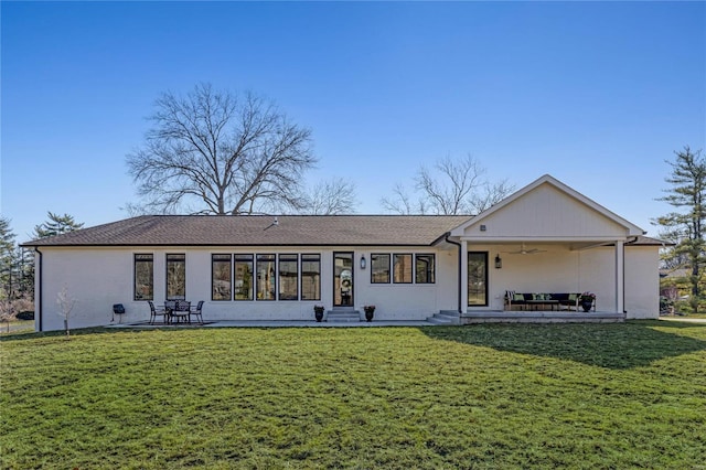 back of house featuring a lawn, a ceiling fan, and a patio