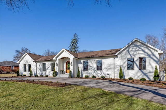 ranch-style house with aphalt driveway and a front yard