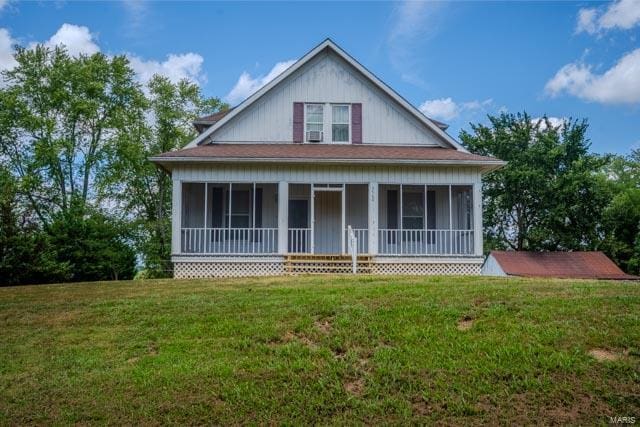 view of front facade with a front yard and a sunroom