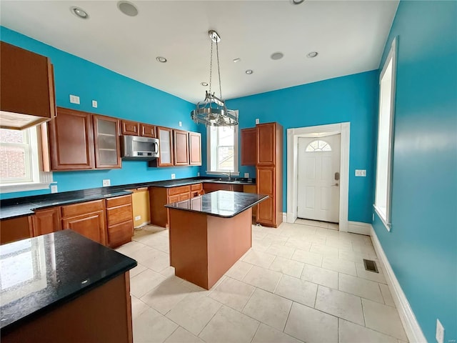 kitchen featuring a center island, sink, hanging light fixtures, and light tile patterned floors