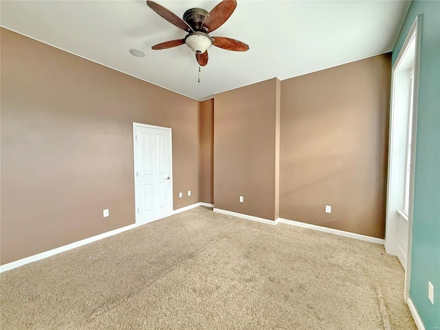 spare room with ceiling fan and carpet