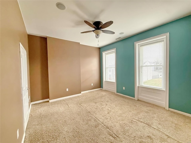 carpeted spare room featuring ceiling fan