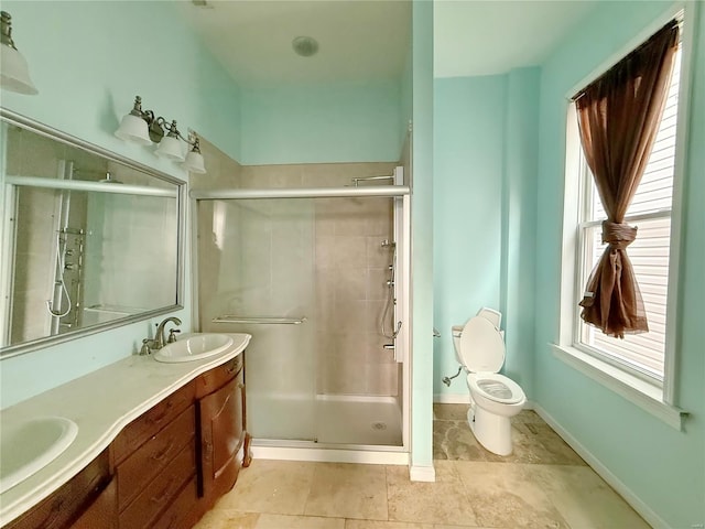 bathroom featuring vanity, a shower with door, and toilet