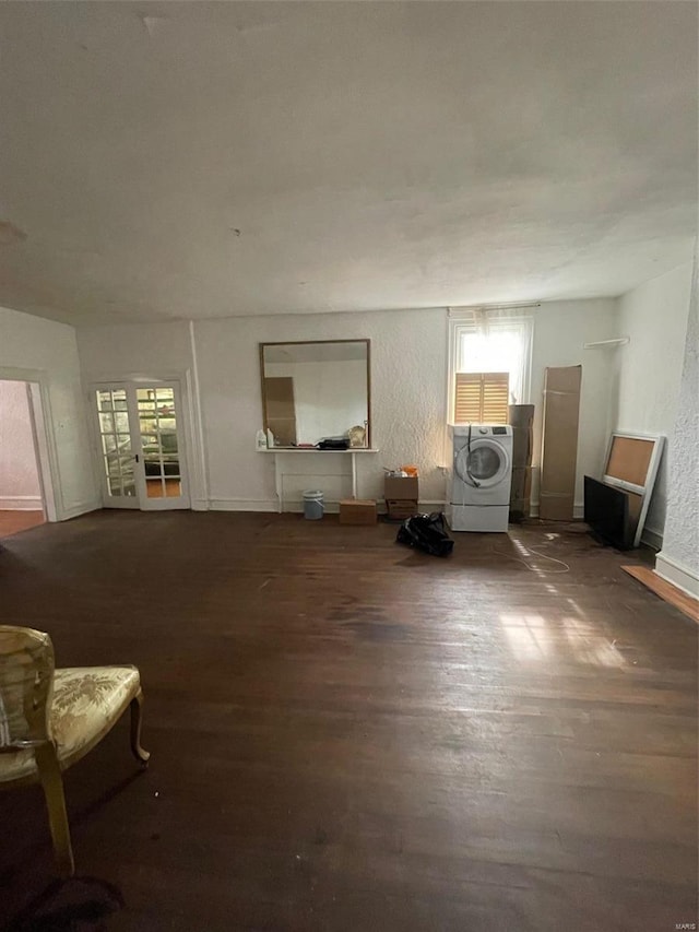 unfurnished living room with dark hardwood / wood-style floors and washer / clothes dryer