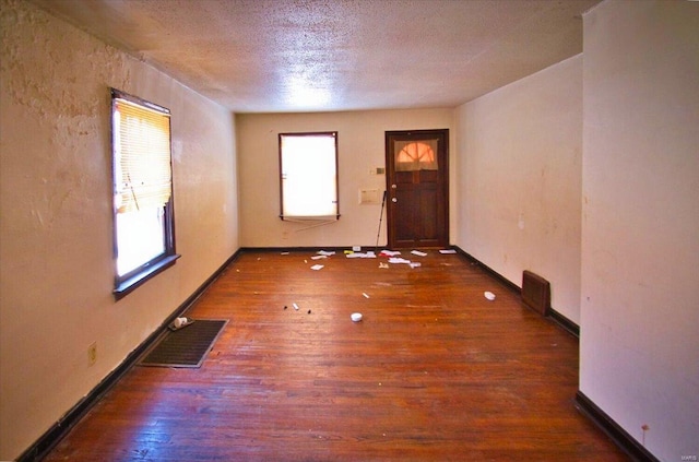 empty room featuring dark hardwood / wood-style floors and a textured ceiling