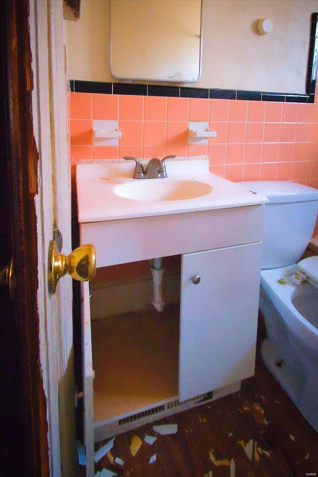 bathroom featuring tile walls, vanity, and toilet